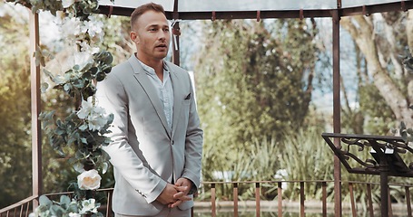 Image showing Waiting, groom and man in wedding and ceremony at alter with anxiety, stress or nervous energy for marriage or commitment. Formal, suit and excited person standing in aisle with flowers and nature