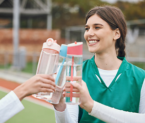 Image showing Cheers, water bottle and woman with hockey team on break together at sports training, match or competition. Smile, celebrate and people on a field for fitness or exercise in victory with teamwork