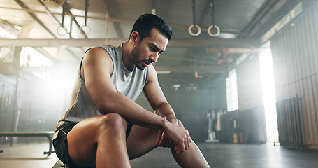 Image showing Fitness, breathing and sweating with a tired man in the gym, resting after an intense workout. Exercise, health and fatigue with a young athlete in recovery from training for sports or wellness