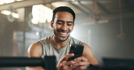 Image showing Happy asian man, phone and fitness on break in social media, communication or networking at gym. Active male person smile for online texting or chatting on mobile smartphone app at indoor health club