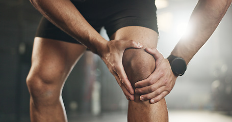 Image showing Fitness, knee pain and hands of man at gym for training with muscle, problem or arthritis. Sports, injury and leg of male athlete with joint massage for fibromyalgia, osteoporosis or bone accident