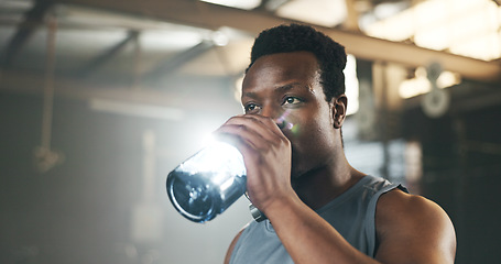 Image showing Black man at gym, water bottle and relax to hydrate in muscle development, strong body and fitness. Commitment, motivation and bodybuilder with drink in workout challenge for health and wellness.