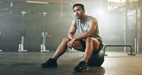 Image showing Fitness, breathing and sweating with a tired man in the gym, resting after an intense workout. Exercise, health and fatigue with a young athlete in recovery from training for sports or wellness