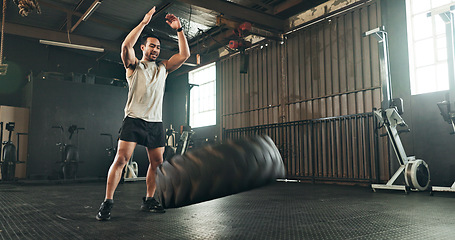 Image showing Gym, man and tire workout for strong muscle, power and action of sports challenge, energy and exercise. Asian bodybuilder, training and flip heavy tractor wheel for fitness, resilience or performance