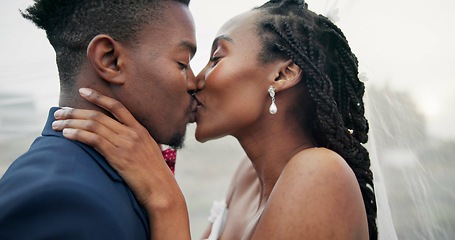 Image showing Outdoor, kiss and black couple with marriage, wedding and hug with happiness, romance and celebration. African man, happy woman and embrace outside, love and bride with groom, romantic and commitment