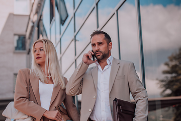 Image showing Modern business couple after a long day's work, walking together towards the comfort of their home, embodying the perfect blend of professional success and personal contentment.