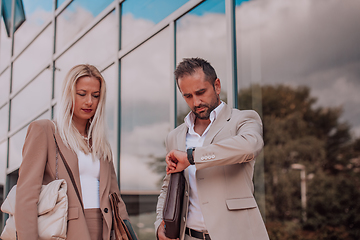 Image showing Modern business couple after a long day's work, walking together towards the comfort of their home, embodying the perfect blend of professional success and personal contentment.