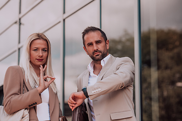 Image showing Modern business couple after a long day's work, walking together towards the comfort of their home, embodying the perfect blend of professional success and personal contentment.