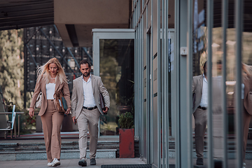 Image showing Modern business couple after a long day's work, walking together towards the comfort of their home, embodying the perfect blend of professional success and personal contentment.