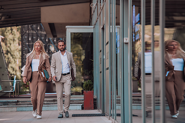 Image showing Modern business couple after a long day's work, walking together towards the comfort of their home, embodying the perfect blend of professional success and personal contentment.