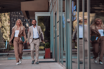 Image showing Modern business couple after a long day's work, walking together towards the comfort of their home, embodying the perfect blend of professional success and personal contentment.