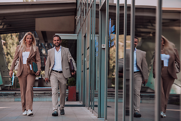 Image showing Modern business couple after a long day's work, walking together towards the comfort of their home, embodying the perfect blend of professional success and personal contentment.