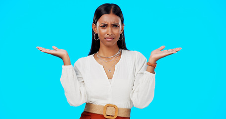 Image showing Comparison, thinking and what hands of woman portrait with choice in a studio with question or idea emoji gesture. Decision, doubt and female person with option, balance or shrug and blue background