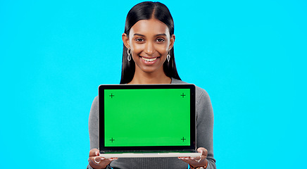 Image showing Portrait, woman and green screen space on laptop for advertising, sign up offer and info in studio. Happy indian model, computer and tracking markers for newsletter, review or deal on blue background