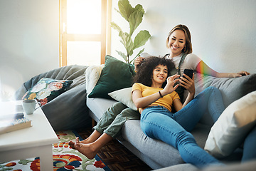 Image showing Women, lgbt couple and smartphone on couch, living room and relaxing together for quality time, videos and bonding. Social media apps, indoors and smiling while streaming online, memes and cellphone