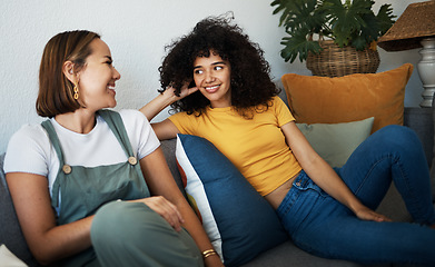 Image showing Conversation, love and lesbian couple relaxing on a sofa in the living room talking and bonding. Happy, communication and young interracial lgbtq women speaking and resting together in lounge at home