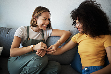 Image showing Conversation, happy and lesbian couple relaxing on a sofa in the living room talking and bonding. Love, communication and young interracial lgbtq women speaking and resting together in lounge at home