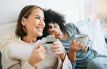 Image showing Coffee, communication and happy lesbian couple on bed bonding and relaxing together. Happy, rest and young interracial lgbtq women laughing, talking and drinking latte in bedroom of modern apartment