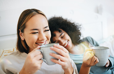 Image showing Coffee, laugh and lesbian couple on bed in conversation for bonding and relaxing together. Happy, rest and young interracial lgbtq women talking and drinking latte in bedroom of modern apartment.