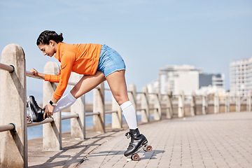 Image showing Woman, roller skates and outdoor in park, stretching legs and training for contest, fitness or health by ocean. Gen z girl, skating and walk for exercise, workout or metro road by sea in Cape Town