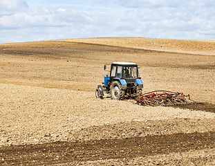 Image showing an old tractor plows the soil