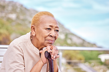 Image showing Depression, walking stick and a sad elderly woman on a park bench with nostalgia in nature during summer. Face, summer and a senior person with a disability looking lonely while in the mountains