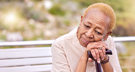 Image showing Depression, walking stick and a sad senior woman on a park bench with nostalgia in nature during summer. Face, summer and an elderly person with a disability looking lonely while in the mountains