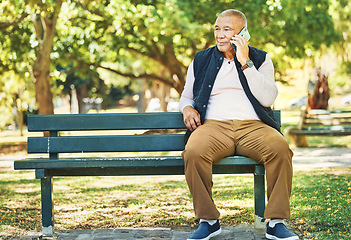 Image showing Senior man, phone call and park with conversation and bench outdoor with communication. Nature, discussion and mobile networking with an elderly male person speaking and listening in urban garden