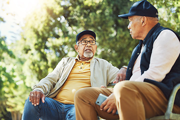 Image showing Elderly friends, men and relax at park bench, talk and bonding outdoor with phone. Senior people sitting together in garden, communication and serious conversation in nature for retirement in spring