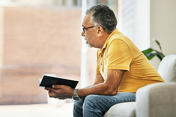 Image showing Senior man, thinking and reading a book on sofa in home living room learning knowledge, information or ideas. Elderly, person and relax in retirement with novel, books or inspiration for fiction