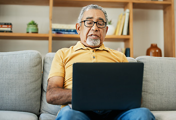 Image showing Typing, senior man and laptop on sofa in home with online research in living room or streaming video, movies or tv show. Elderly, person or writing on computer in retirement for blog or communication