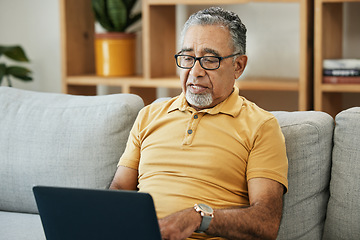 Image showing Senior man, typing and laptop on sofa in home with online research in living room or streaming video, movies or tv show. Elderly, person or writing on computer in retirement for blog or communication