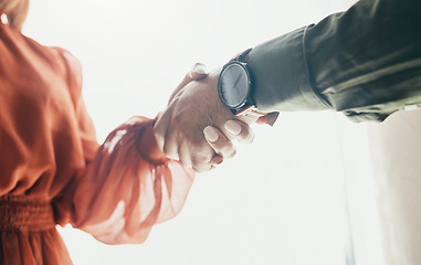 Image showing Creative people, handshake and partnership in meeting, b2b deal or teamwork below at office. Low angle of man and woman shaking hands for startup, introduction or thank you in agreement at workplace