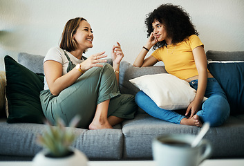Image showing Women, friends relax and conversation in a home with gossip, discussion and happy in a living room. Couch, smile and female person on sofa with communication together in a house lounge with speaking
