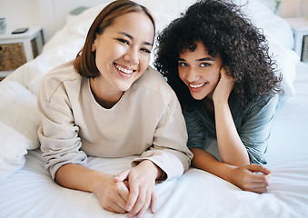 Image showing Love, smile and portrait of lesbian couple on bed for bonding, resting and relaxing together. Happy, romance and young interracial lgbtq women laying in the bedroom of modern apartment or home.