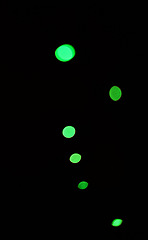 Image showing Green light, bokeh and glow on black background isolated on a mockup space. Blur, dark backdrop and defocused shine, sparkle or glitter at night for Christmas, holiday or party with magic color dots