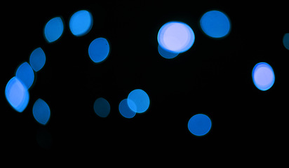 Image showing Blue, lights and bokeh in a studio with dark background for celebration, event or party. Confetti, glitter and color sparkles for magic, shine or glow for festive by black backdrop with mockup.