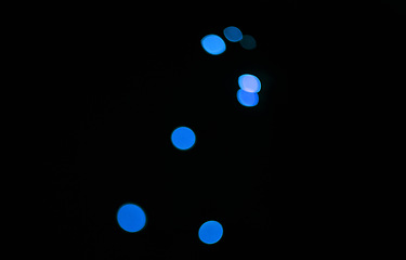 Image showing Bokeh, blue dots and black background with glow or sparkle, mockup space with light, texture and flare from festival. Glitter, art and texture with graphic design, special effects on dark backdrop