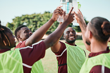 Image showing Soccer team, water bottle and cheers with teamwork, achievement and community on grass field. Fitness, workout and sport training of men group with smile and celebration from game outdoor with drink