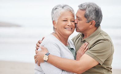 Image showing Senior couple, kiss and love at beach for holiday, vacation and tropical travel in retirement. Happy man, elderly woman and hug of affection at ocean for trust, support and loyalty to partner on date