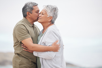 Image showing Senior, couple and kiss on the beach for retirement vacation, holiday or adventure in summer with care. Elderly, man or woman for walking by ocean or sea with journey and happiness for relax and love