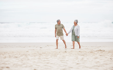 Image showing Senior, couple and hand holding on the beach for retirement vacation, holiday or adventure in summer. Elderly, man and woman for walking by ocean or sea with journey and happiness for relax and love