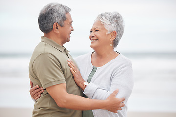 Image showing Elderly, couple and hug with smile on beach in nature together for holiday, relax and connection outdoor. Commitment, man or woman with love embrace for peace, trust and vacation at ocean or sea