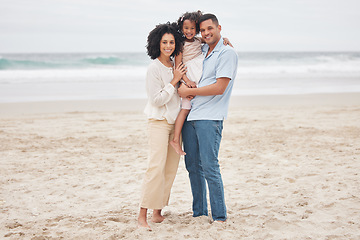 Image showing Hug, portrait and a family at the beach for a vacation, travel or walking by the ocean. Happy, care and a young mother, father and girl kid at the sea for a holiday, bonding or together in summer