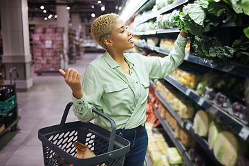 Image showing Woman, grocery shopping and vegetables choice, discount and sale or wholesale promotion of healthy food in basket. Happy African customer with spinach in retail, convenience store or supermarket deal