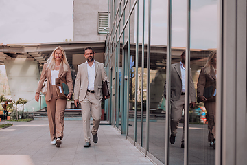 Image showing Modern business couple after a long day's work, walking together towards the comfort of their home, embodying the perfect blend of professional success and personal contentment.