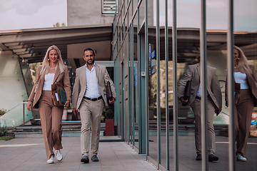 Image showing Modern business couple after a long day's work, walking together towards the comfort of their home, embodying the perfect blend of professional success and personal contentment.