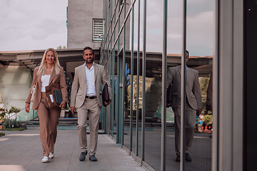 Image showing Modern business couple after a long day's work, walking together towards the comfort of their home, embodying the perfect blend of professional success and personal contentment.