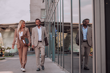 Image showing Modern business couple after a long day's work, walking together towards the comfort of their home, embodying the perfect blend of professional success and personal contentment.