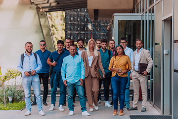 Image showing A diverse group of businessmen and colleagues walking together by their workplace, showcasing collaboration and teamwork in the company.